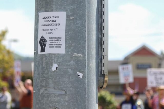 On Monday afternoon, a group of students and adults gathered during a walkout at Roseburg High School to protest the potential arrival of U.S. Immigrations and Customs Enforcement (ICE) to Roseburg.

The demonstration was held at 2 p.m., just before the end of the school day, on a patch of grass across the road from the school’s entrance. There, a crowd waved signs for passing motorists and were met with cheers, jeers and honking horns.

The demonstration was held in response to a contract opportunity listed on the United States System for Award Management (SAM) website, in which ICE is seeking private office space or workstations in cities across the U.S.

Among the cities listed was Roseburg. According to the contract opportunity description, ICE would occupy the space for a 12-month term.

For More Information Please Visit www.nrtoday.com