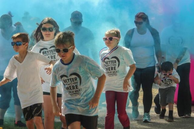 Myrtle Creek's Millsite park was filled with color and music on Saturday as families celebrated the first ever Better With YOU Here Suicide Awareness Color Walk.

Held from 9 a.m.–1 p.m., the free event welcomed guests to don a white T-shirt and walk laps around the park, stopping at stations along the way to get doused in different shades of colored powder.

After turning shades of rainbow, guests were then invited to grab hot dogs, and participate in a raffle for baskets of goods donated by local businesses. Proceeds for the raffle went to the South Umpqua High School (SUHS) Hope Squad, a peer-to-peer suicide prevention program.

For younger walkers, water slides, a coloring table and foam cannons were present for additional activities.

The idea for the event came from Riley Thomas, a graduate of SUHS who was inspired to raise awareness for suicide after a classmate took their own life. After  mentioning the idea to her church, she was put in contact with local organizations to make that wish a reality.

To kick off the run, Thomas shared some advice for anyone in the crowd who may be going through their own internal struggles.

"I know that I am not alone in this pain. I know that a lot of you are going through so much that none of use will know," Thomas said. "Look around you. Remember that no matter what, you have a community. You have a family and you are not alone. There is so much hope in this community. It is okay to lean on one another, and I know that they will be here to help and love and support you."

For More Information Please Visit www.nrtoday.com
